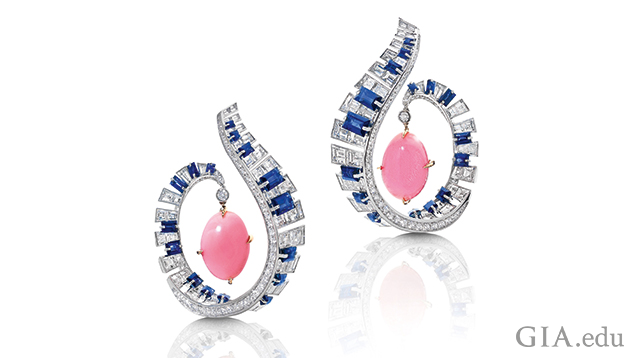 The frames of the earrings are designed a scroll from which a pink conch pearl dangles. The scrolls are comprised of blue sapphires and diamonds to look like piano keys. The frames of the earrings are designed a scroll from which a pink conch pearl dangles. The scrolls are comprised of blue sapphires and diamonds to look like piano keys.