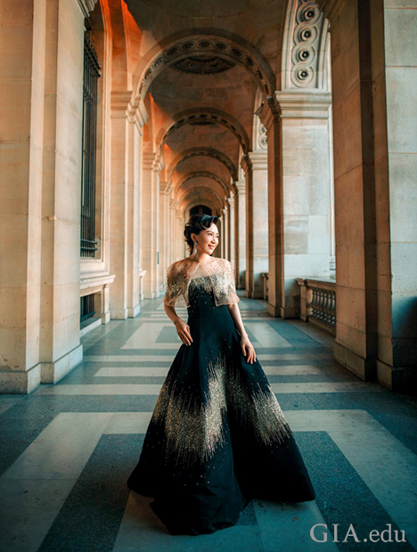 Woman stands in a long, ornate hallway, dressed in formal gown. Woman stands in a long, ornate hallway, dressed in formal gown.